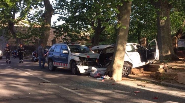 El cotxe encastat entre un arbre i el vehicle dels mossos. J. Ribas