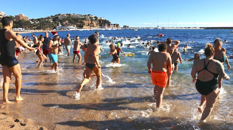 Participants entrant a l'aigua en el primer bany de l'any a la platja de Sant Feliu de Guíxols. ACN