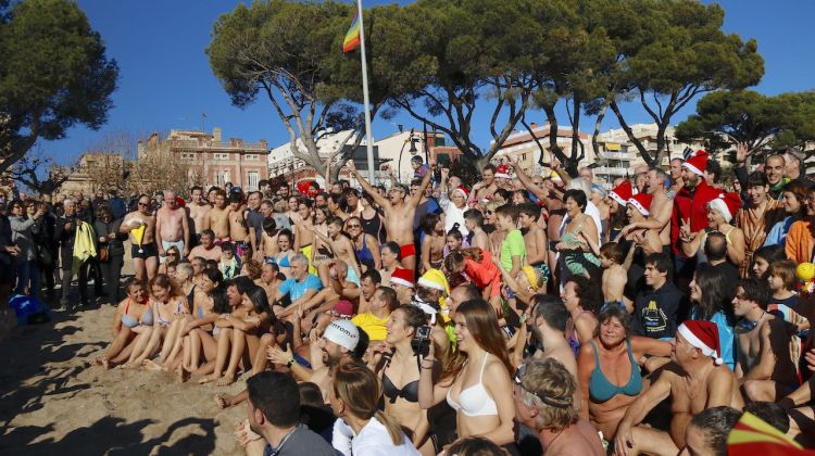 Foto de família dels participants del primer bany a la platja de Sant Feliu de Guíxols. ACN