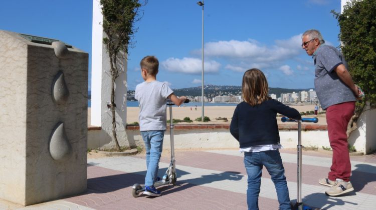 Pla mitjà de dos nens amb patinets amb el seu avi al Passeig de Palamós. Leyre Barceló