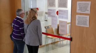 Una parella davant de la porta del Registre Civil dels Jutjats de Girona tancada al públic pel coronavirus