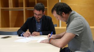 L’alcalde, Lluc Salellas, firmant el conveni amb un treballador