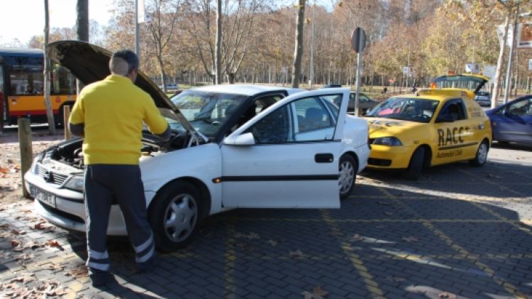 Un tècnic del RACC revisant un cotxe avariat a Girona © ACN