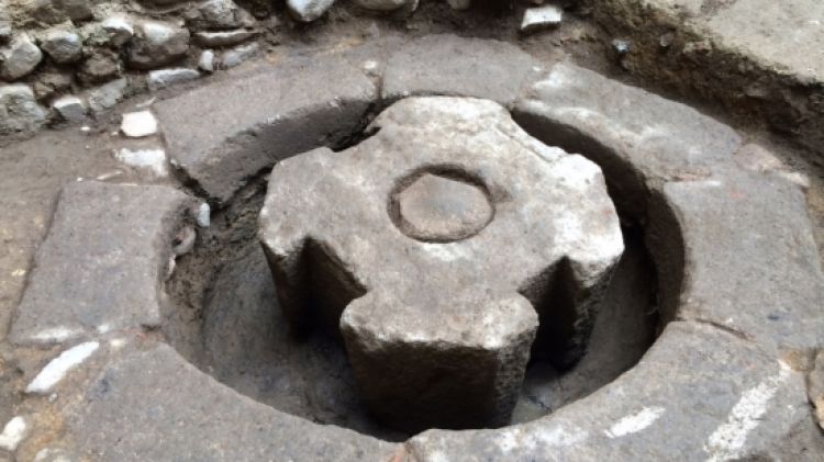 La pedra de lliura o contrapès de la gran premsa de biga medieval desenterrada © ACN