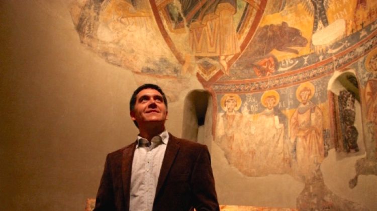 Martí Gironell a sota d'un absis amb pintures del romànic al MNAC © ACN