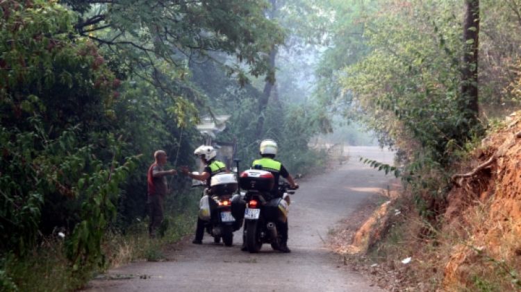 Dos agents advertint a un veí que ha de desallotjar la zona © ACN