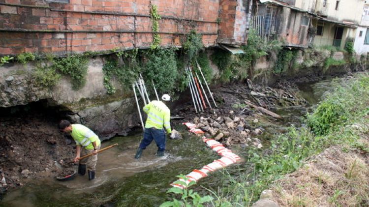 Obrers treballant per reforçar els fonaments d'un edifici afectat per l'erosió del pas d'aigua © ACN