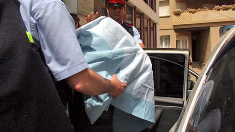Els mossos ajuden el detingut a entrar al cotxe policial © ACN