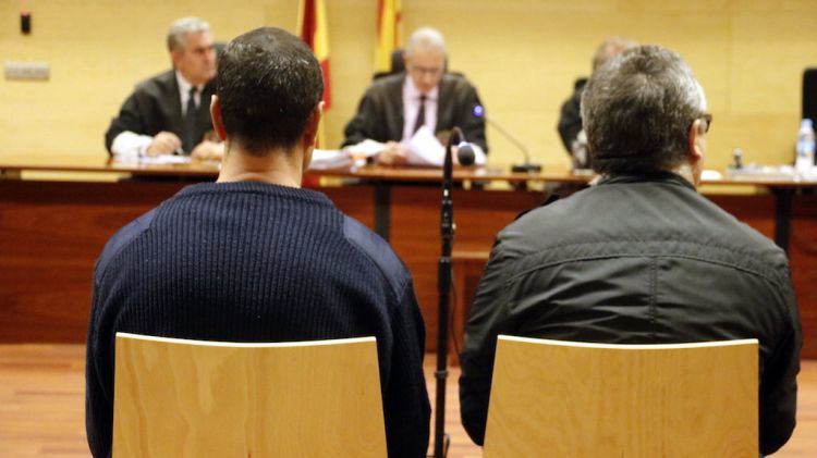 D'esquenes i a l'esquerra, l'acusat de violar una indigent a Girona durant el judici © ACN