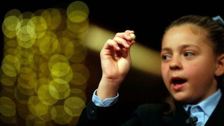 Una nena de San Ildefonso mostra una bola premiada © ACN