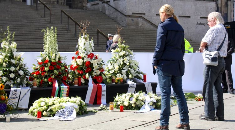 Dues persones miren les ofrenes florals a les víctimes del vol de Germanwings. ACN
