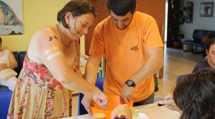 Dos usuaris de la Fundació Adis realitzant un taller de cuina. ACN