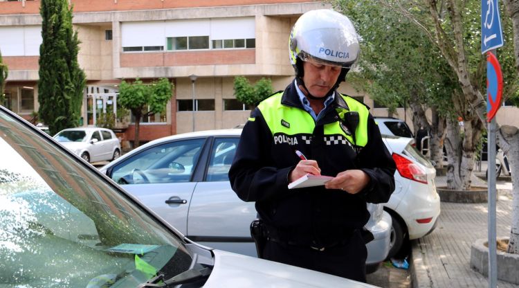 Un agent de la Policia Municipal de Girona posant una multa (arxiu). ACN