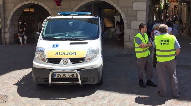 Els auxiliars municipals situats al costat d'un vehicle de la Policia Municipal de Girona. ACN