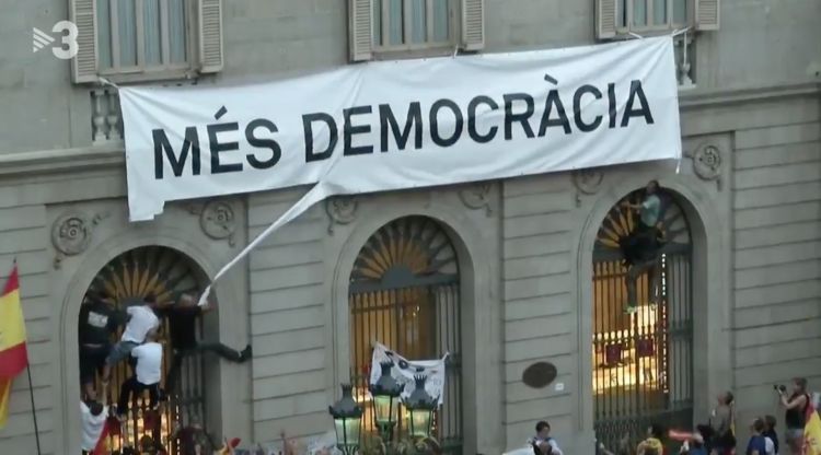 Els manifestants espanyolistes arrencant la pancarta de "Més democràcia". TV3