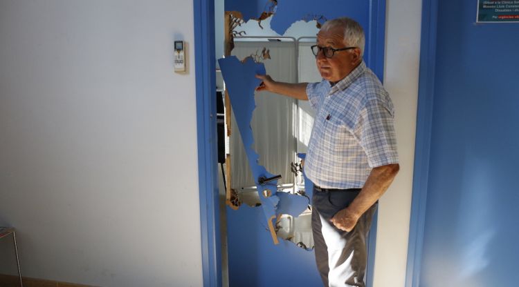 L'alcalde d'Esponellà, Joan Farrés, mostra la porta del dispensari que la Guàrdia Civil va destrossar. ACN
