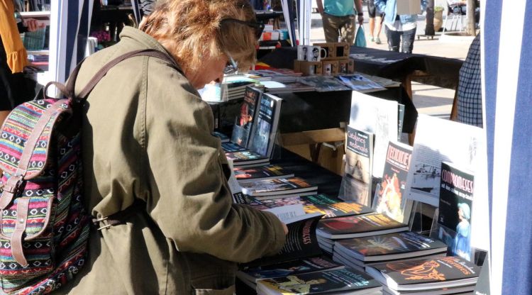 Una lectora mira diversos llibres en una parada, aquest matí. ACN