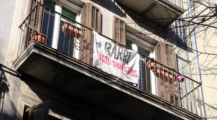 Un balcó de la Rambla on hi llueix una pancarta que reclama menys habitatges d'ús turístic al Barri Vell de Girona. ACN