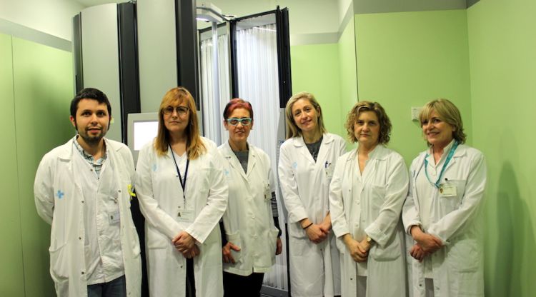 L'equip de dermatologia de l'hospital Trueta davant de la cabina de fototeràpia