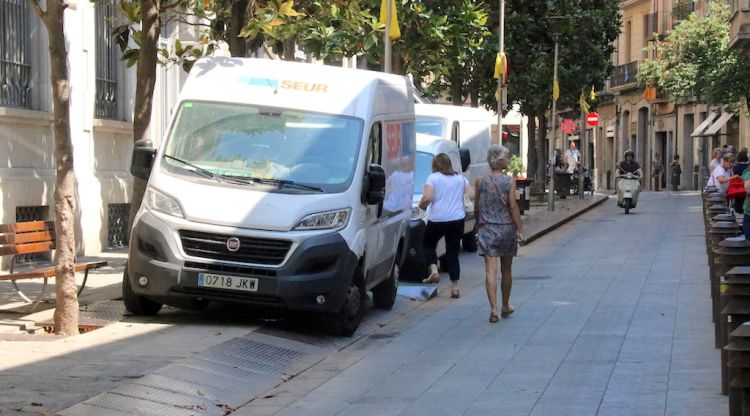 El Carrer Santa Clara de Girona amb tres furgonetes de repartiment a sobre de la vorera per falta d'espai (arxiu). ACN
