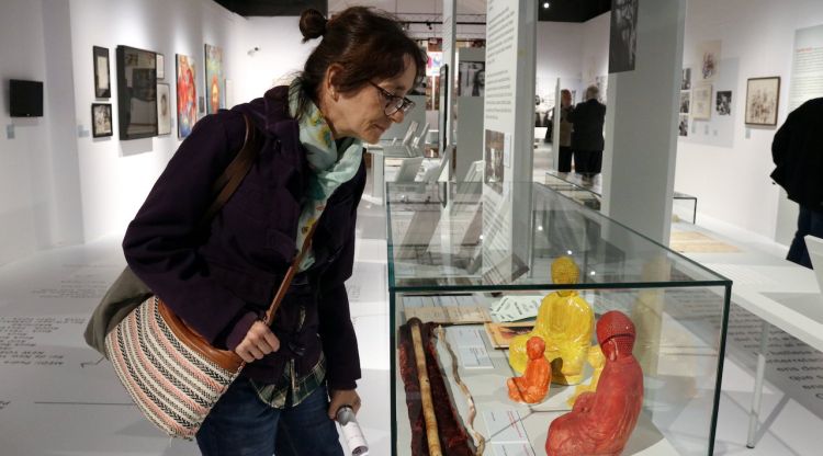 La vídua de Damià Escuder, Maria Capellas, observa una de les vitrines de la mostra del Museu d'Història de Girona. ACN