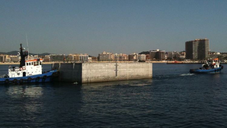 El primer dels quatre calaixos que formaran el nou dic exterior del port de Llançà ha arribat amb remolcador a Palamós