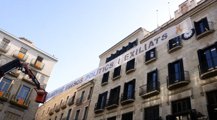 La pancarta on s'hi pot llegir 'Llibertat presos polítics i exiliats' que creua de punta a punta la plaça del Vi de Girona. ACN