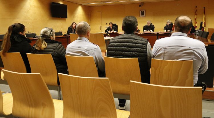 Els tres acusats de falsificació de moneda i documents oficials asseguts en el banc dels acusats de l'Audiència de Girona. ACN