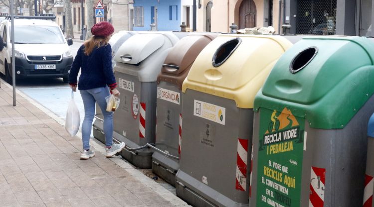 Una noia llançant les escombraries avui en una zona de contenidors de Sant Feliu de Guíxols. ACN