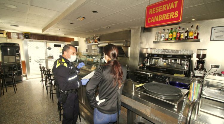 Un agent de la Policia Local de Blanes comunicant el tancament dels allotjaments turístic decretat pel govern espanyol