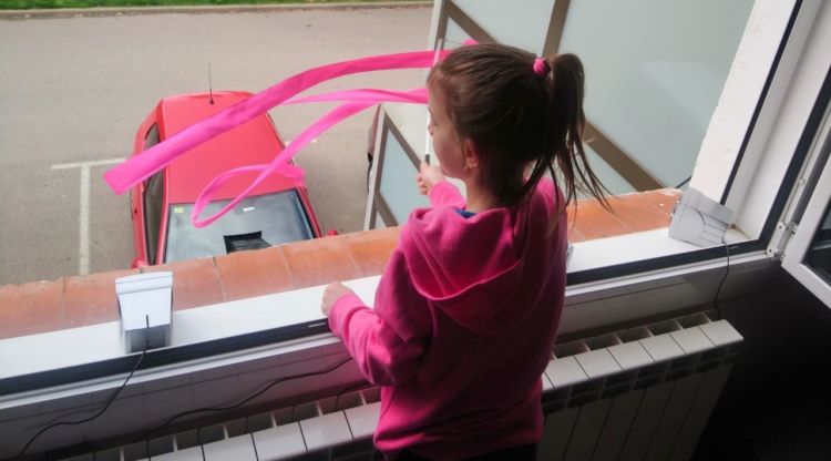 Una nena mentre balla la cançó a la finestra de casa seva a Ripoll. ACN