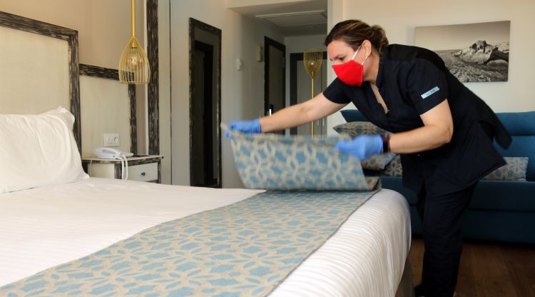 Una de les treballadores del Parkhotel San Jorge de Calonge, traient el plaid decoratiu del llit d'una de les habitacions. ACN