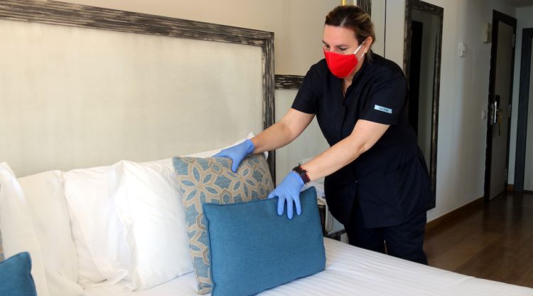 Una de les treballadores del Parkhotel San Jorge de Calonge, traient els coixins decoratius del llit d'una de les habitacions. ACN