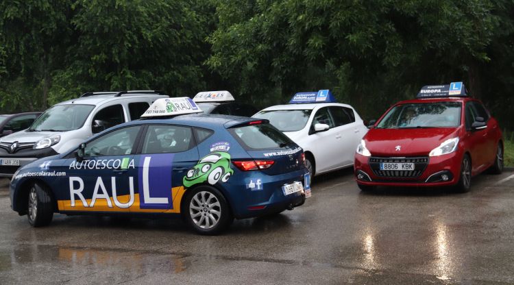 Tres cotxes d'autoescoles gironines a punt per començar l'examen pràctic de conduir a l'aparcament de Fontajau. ACN