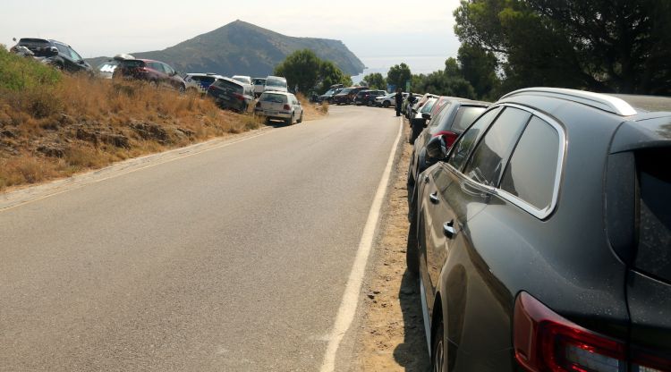 La carretera que baixa cap a Cala Montjoi amb cotxes aparcats a banda i banda. ACN