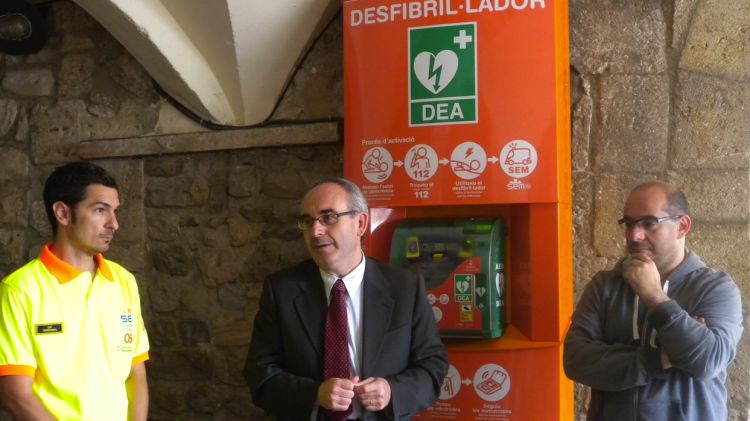 Jaume Heredia, Josep Marigó i Lluís Guinó al costat del desfibril·lador de la plaça Llibertat de Besalú © ACN