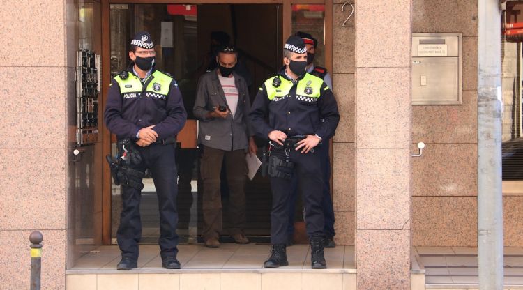 Agents de la policia de Girona i dels Mossos a les portes de l'edifici on han trobat la dona a. ACN