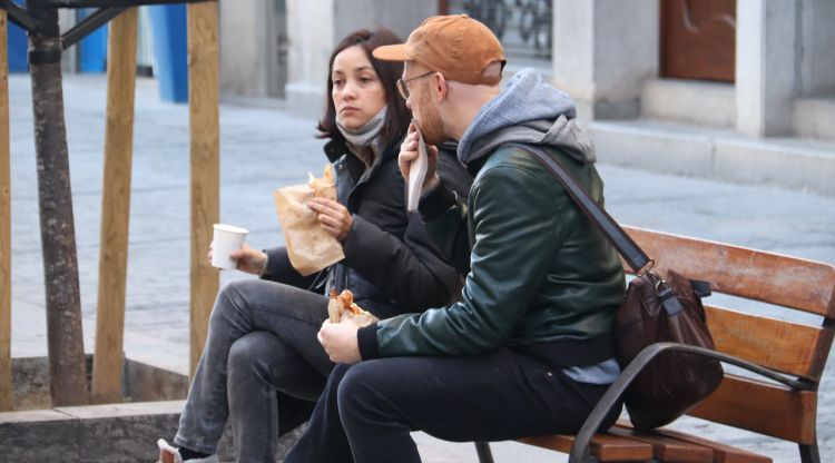 Una parella esmorzant en un banc públic de la Rambla de Girona un cop superada l'hora d'obertura, aquest matí. ACN
