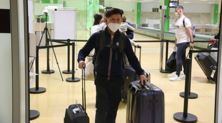 Un jove arribant per la porta i la cua de gent a l'aeroport de Girona Costa Brava. ACN