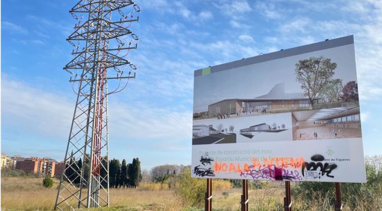 El cartell anunciant el nou pavelló, amb pintades en contra de l'antena. ACN