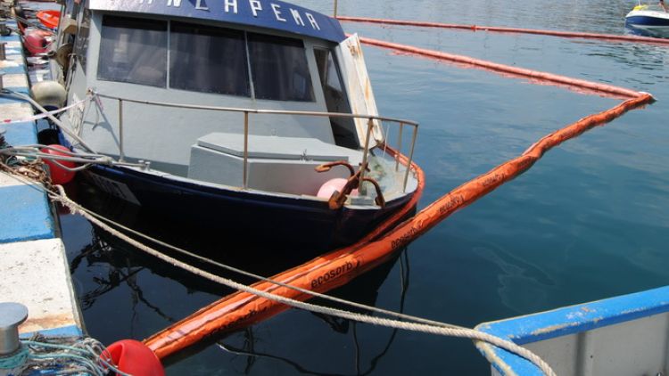 L'embarcació envoltada de bosses pneumàtiques per a contenir la fuita © Ràdio Sant Feliu