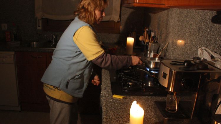 Una veïna de Llambilles cuinant amb la llum de les espelmes © ACN