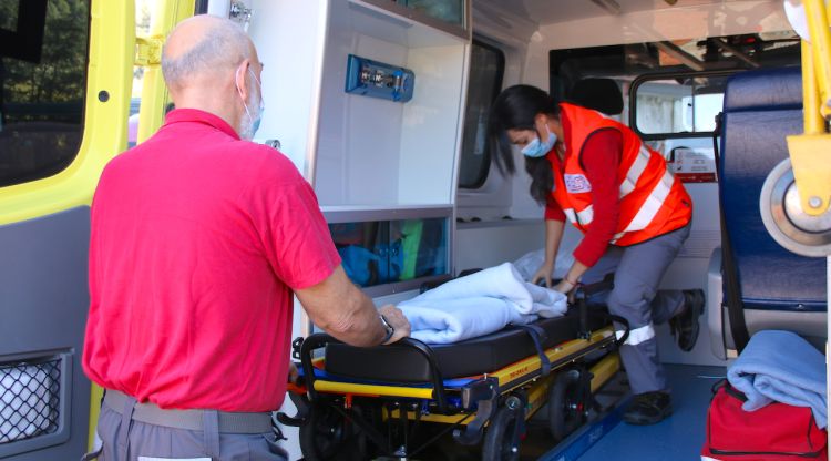 Dos treballadors de TSC preparant una ambulància per traslladar un pacient. ACN