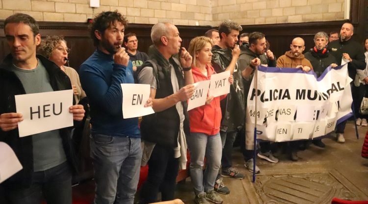 Diversos agents de la Policia Municipal de Girona toquen el xiulet en protesta per les condicions laborals minuts abans de començar el plenari municipal. ACN