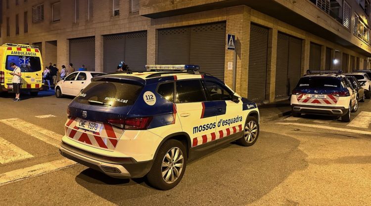 Cotxes patrulla dels Mossos d'Esquadra i una ambulància del SEM a l'entorn d'un edifici en un dels pisos del qual s'ha trobat una dona morta. ACN