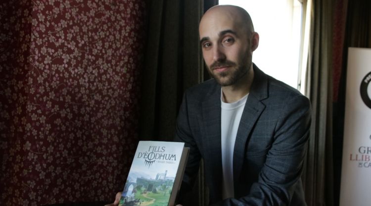Roger Tarrés, autor de la trilogia ‘Fills d'Èodhum’ (Fanbooks), amb el primer llibre de la saga 'L'amenaça verda'. ACN