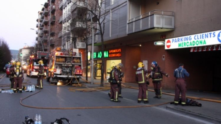 Bombers treballant en l'extinció del foc a l'aparcament i eliminant el fum que havia quedat acumulat © ACN