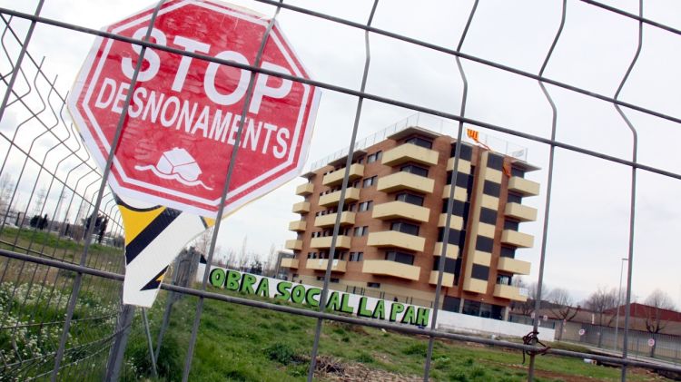 Els membres de la PAH de Girona han omplert amb cartells tot el tancat que envolta el terreny del bloc de pisos i l'hort © ACN
