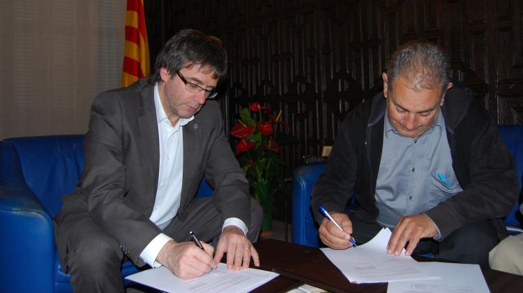 Carles Puigdemont i Ramon Macaya signant el conveni