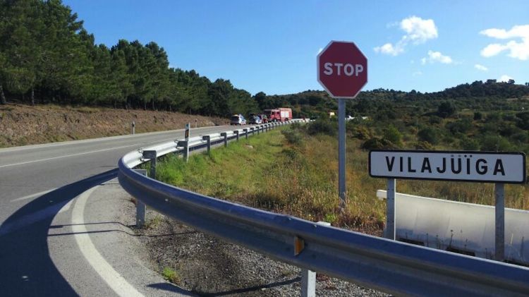 Un cartell de Vilajuïga amb l'accident entre el motorista i el cotxe al fons © ACN
